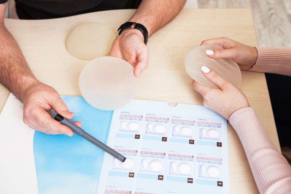 Ein plastischer Chirurg zeigt ein Muster-Set eines Silikonimplantats.
